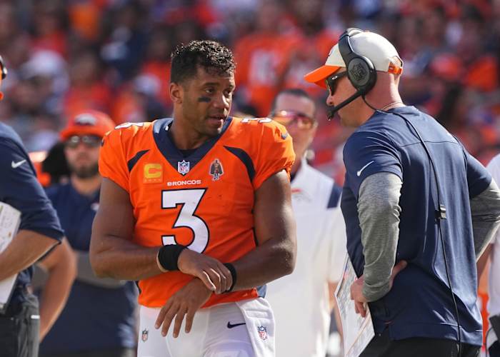 Denver Broncos head coach Nathaniel Hackett talks with Denver Broncos quarterback Russell Wilson (3) in the second quarter against the Houston Texans at Empower Field at Mile High.